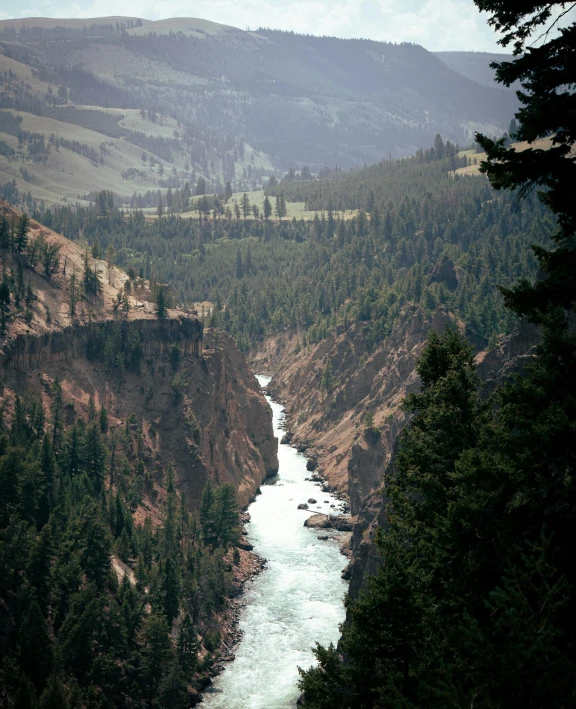 the river and surrounding hills are in a large canyon