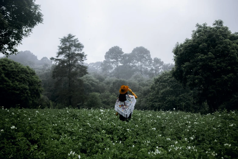 a woman wearing a hat while standing in a field