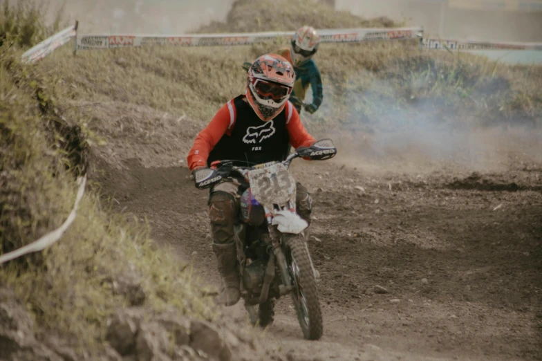 a dirt biker in black and red gear rides a dirt bike