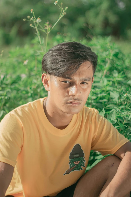 a boy is sitting in a green field of grass