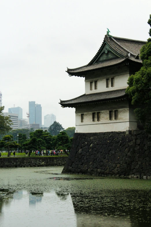 a building near a pond with trees in front