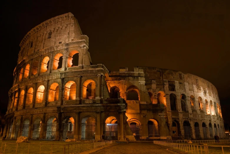 a large ancient structure in the night with many windows