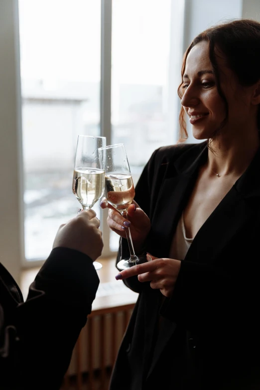 a woman is giving another woman a glass of wine