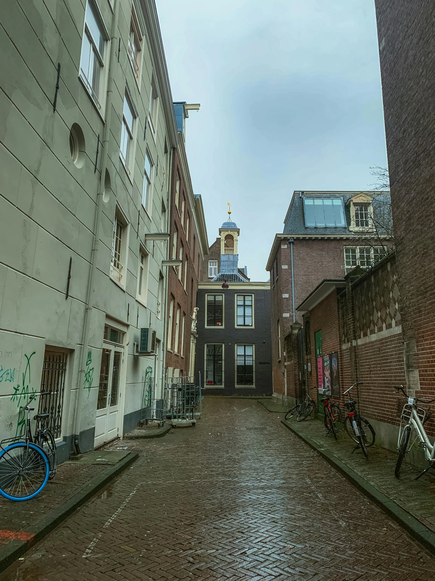 an alley way with bikes, bicycles and houses