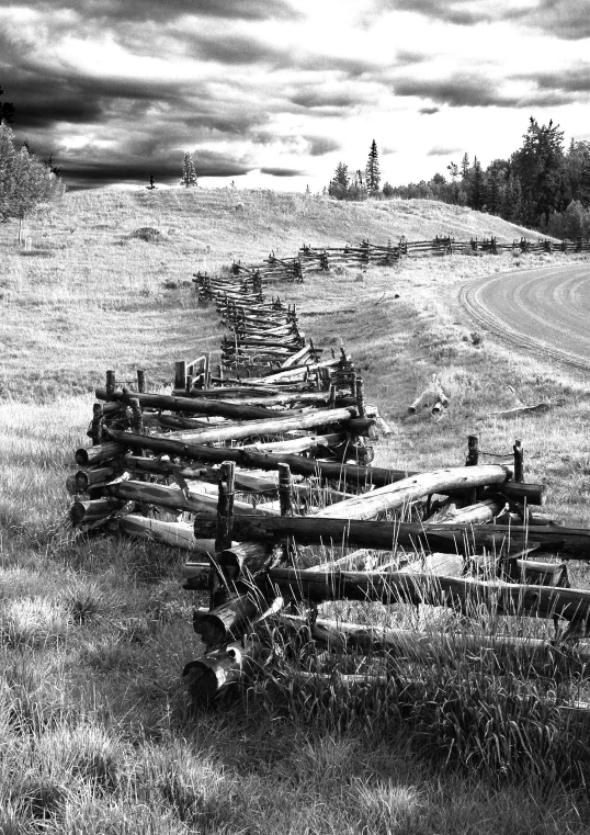 the fence is made of wood and has multiple posts