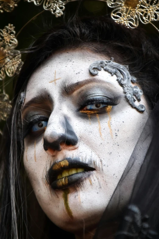 a woman is painted in white with black and yellow face paint