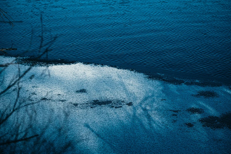 blue water looks over the edge of a sandy shoreline