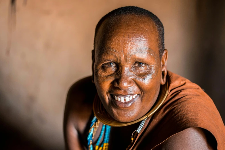 a smiling woman has her arm around her head