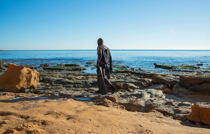 a statue on top of rocks in the beach