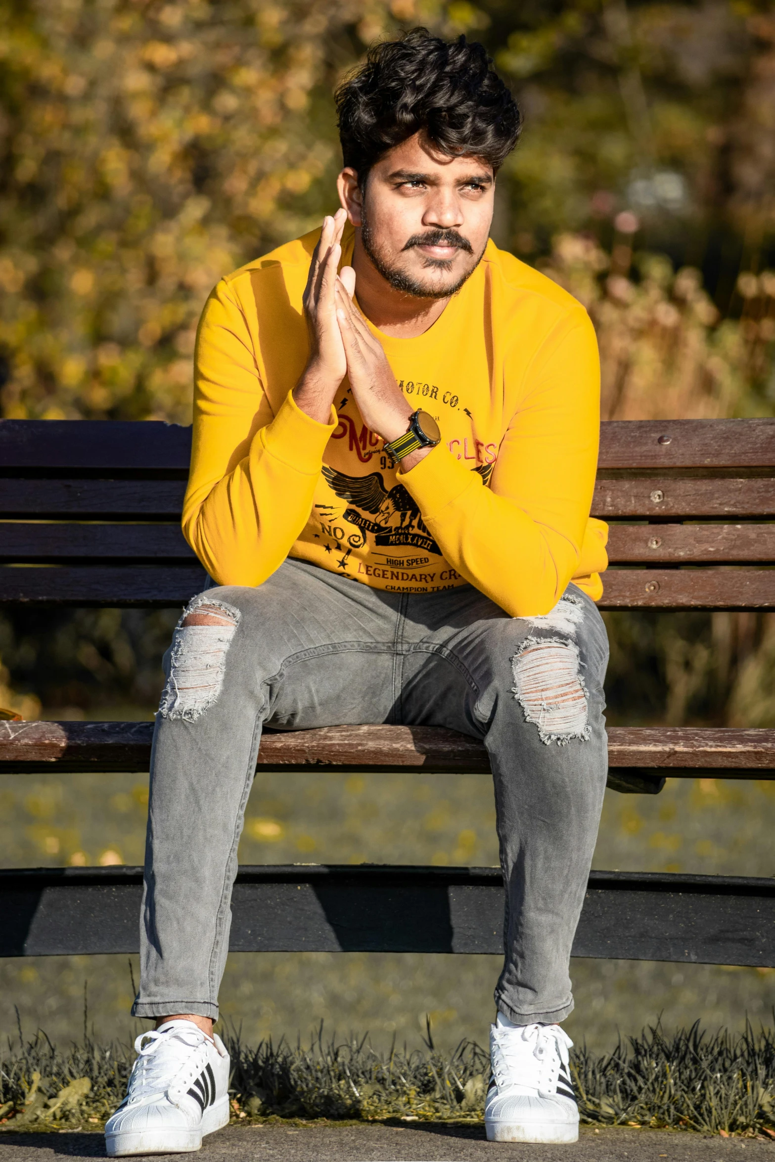 a man is sitting on a bench clapping