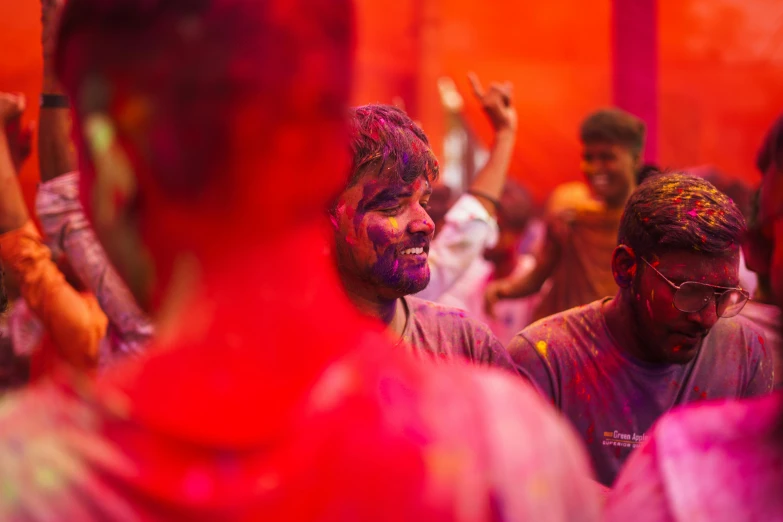 a man covered in bright red and purple paint, dancing