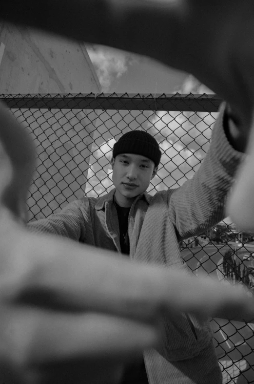 a man that is standing up in front of a fence