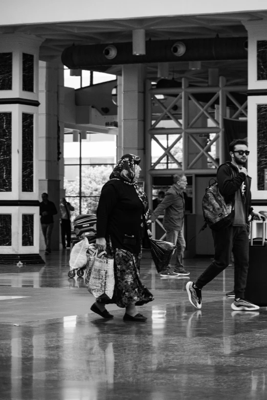 two women walking through an airport carrying luggage