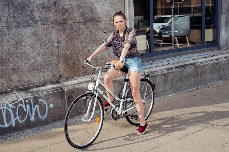 a girl riding her bicycle in front of a building