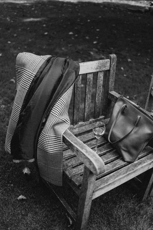 two purses sitting on top of a bench near a blanket