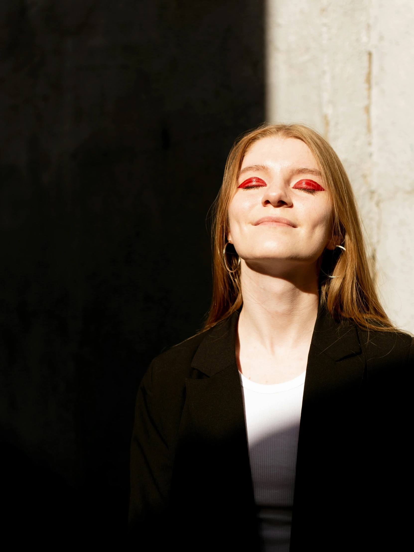 a woman looking up in the sun wearing red eyes