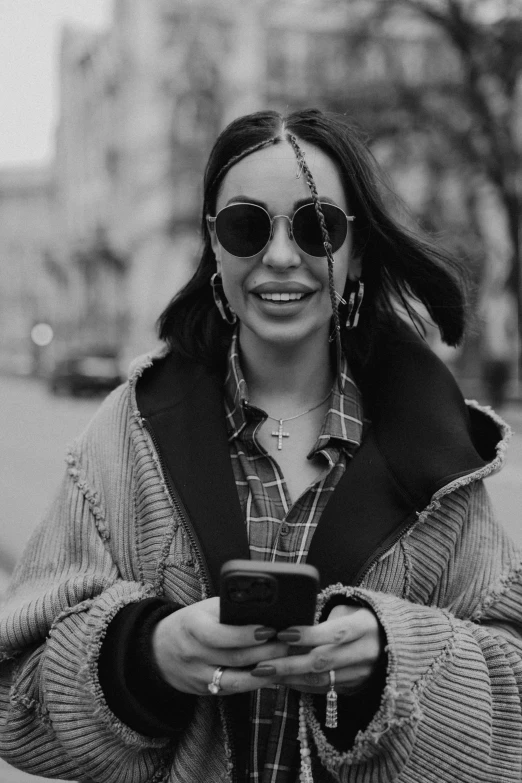 a person standing outside and looking at a cell phone