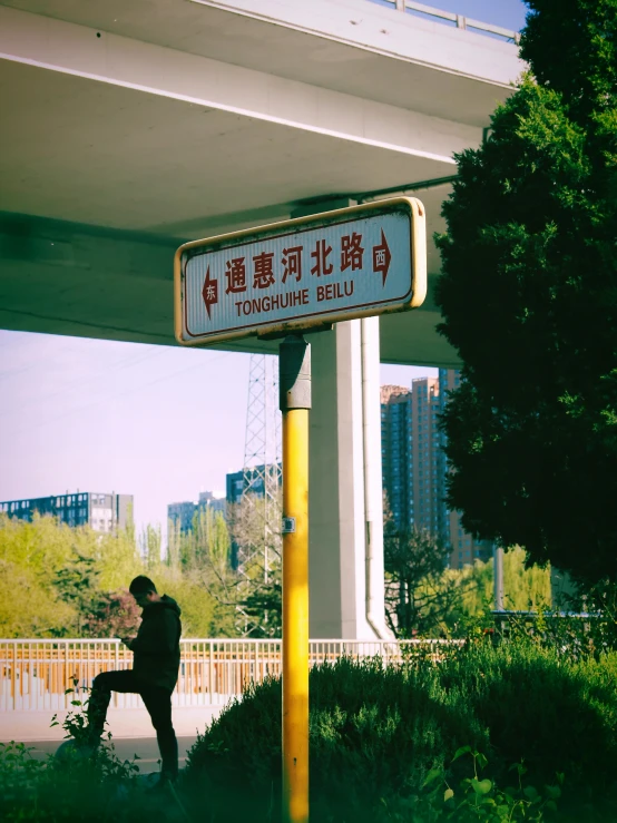 an asian street sign in front of a bridge