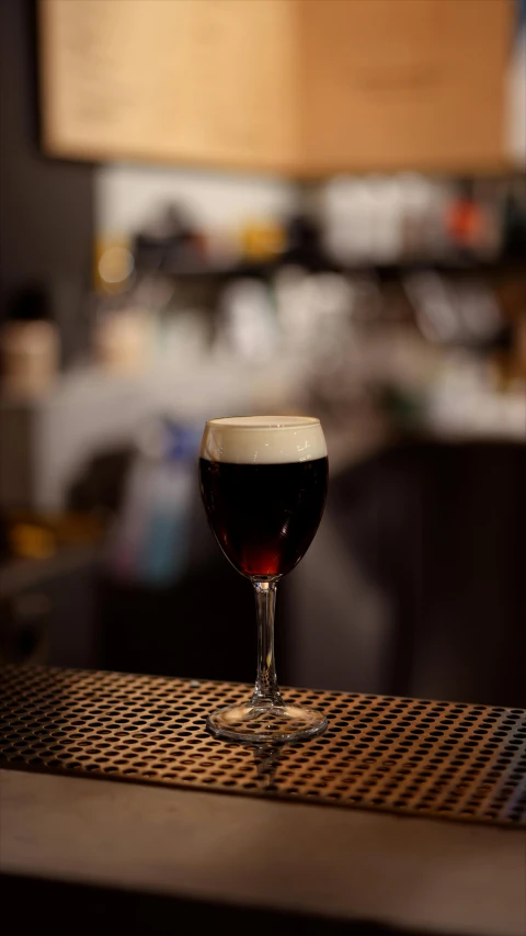 a glass on top of a table with some liquid in it