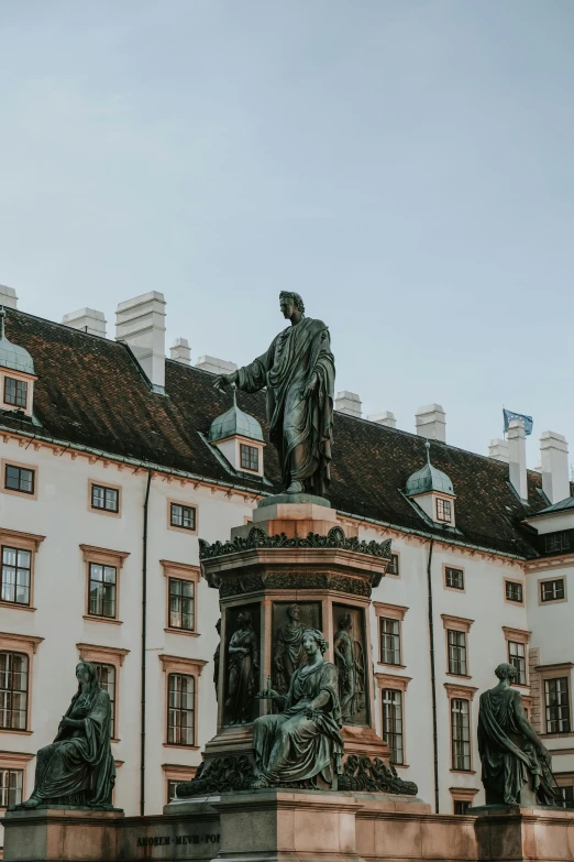 statues on the back of a building with sky in background