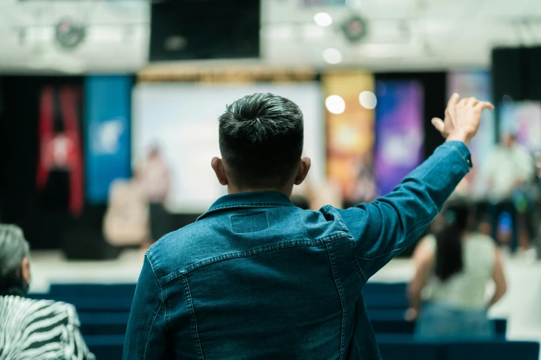 a man raising his hands at an event