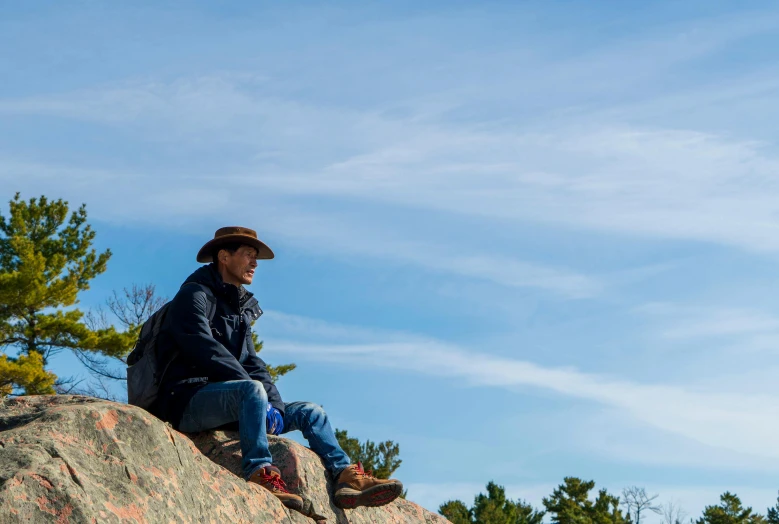 the man is sitting on top of a rock