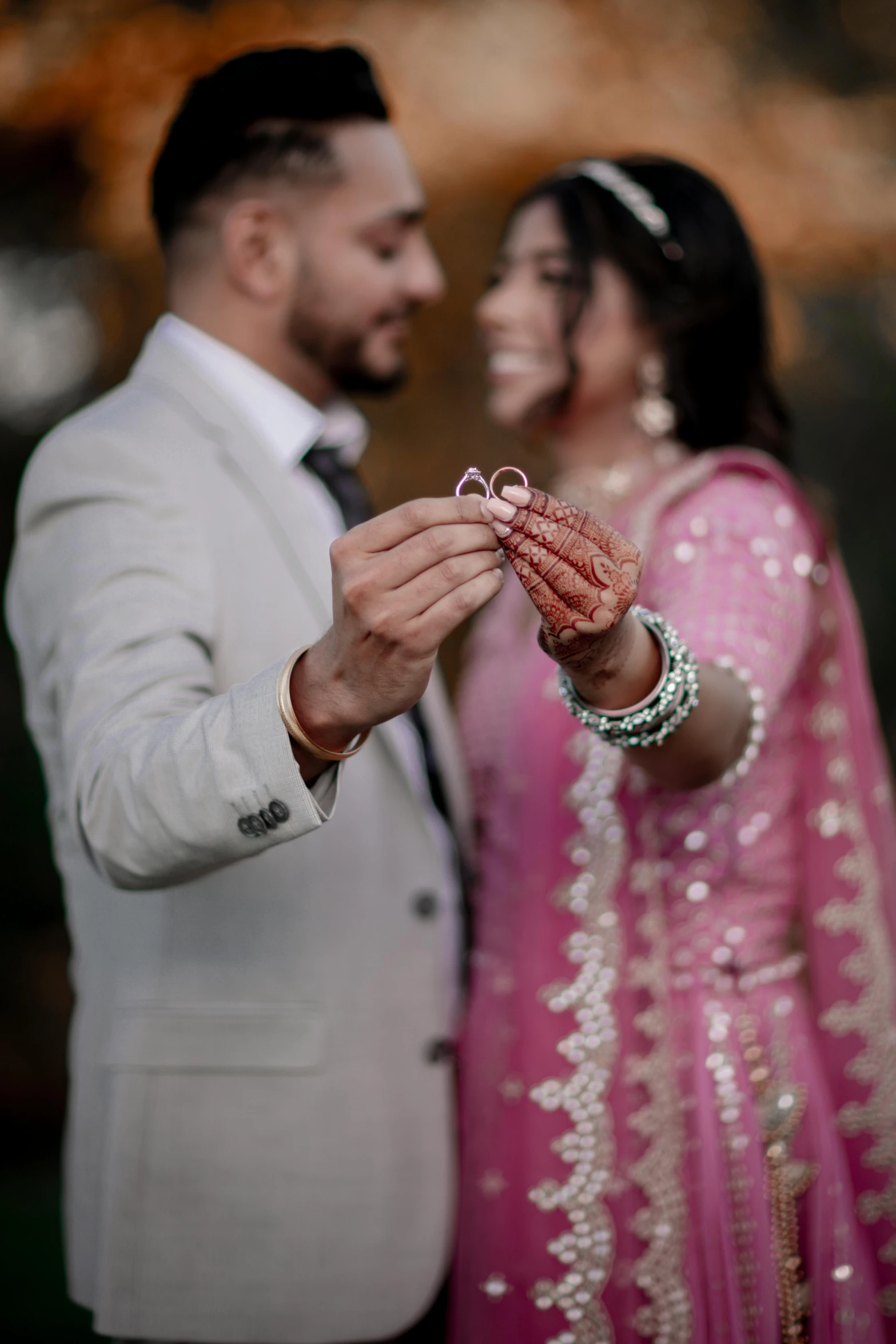 an indian couple holding their wedding rings together