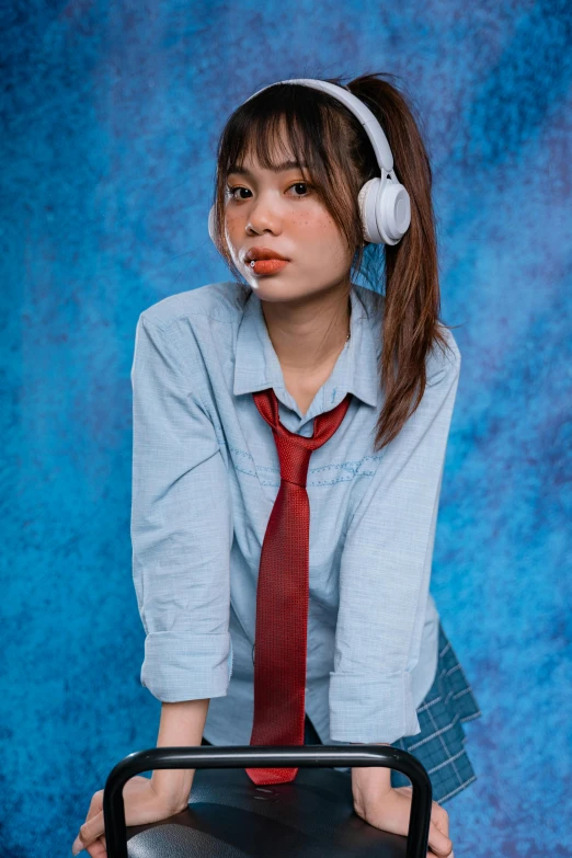 a girl with headphones posing in front of a suitcase