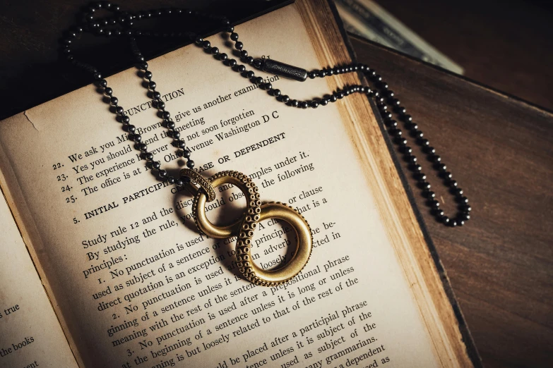 a book on a table with a necklace on it