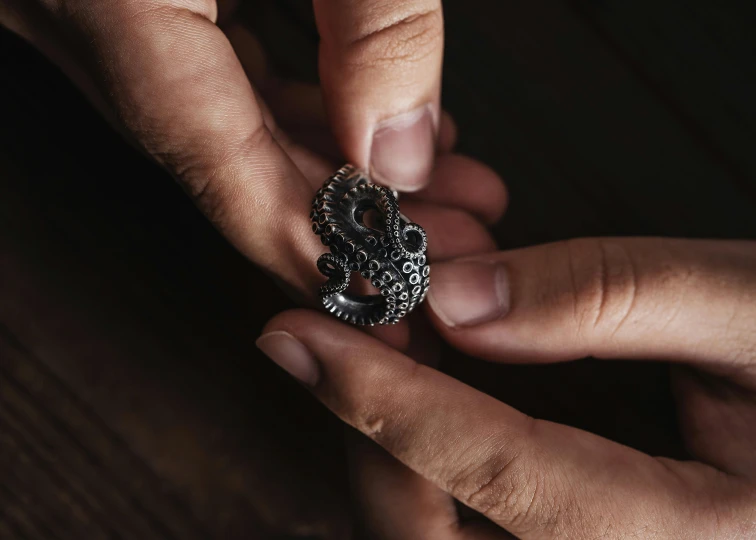 a person holds out a ring with the middle finger