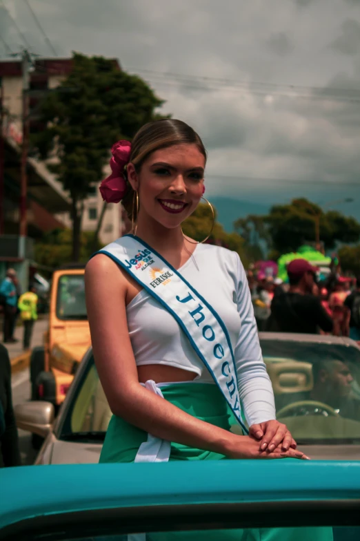 a woman poses beside a convertible car as she poses for a po