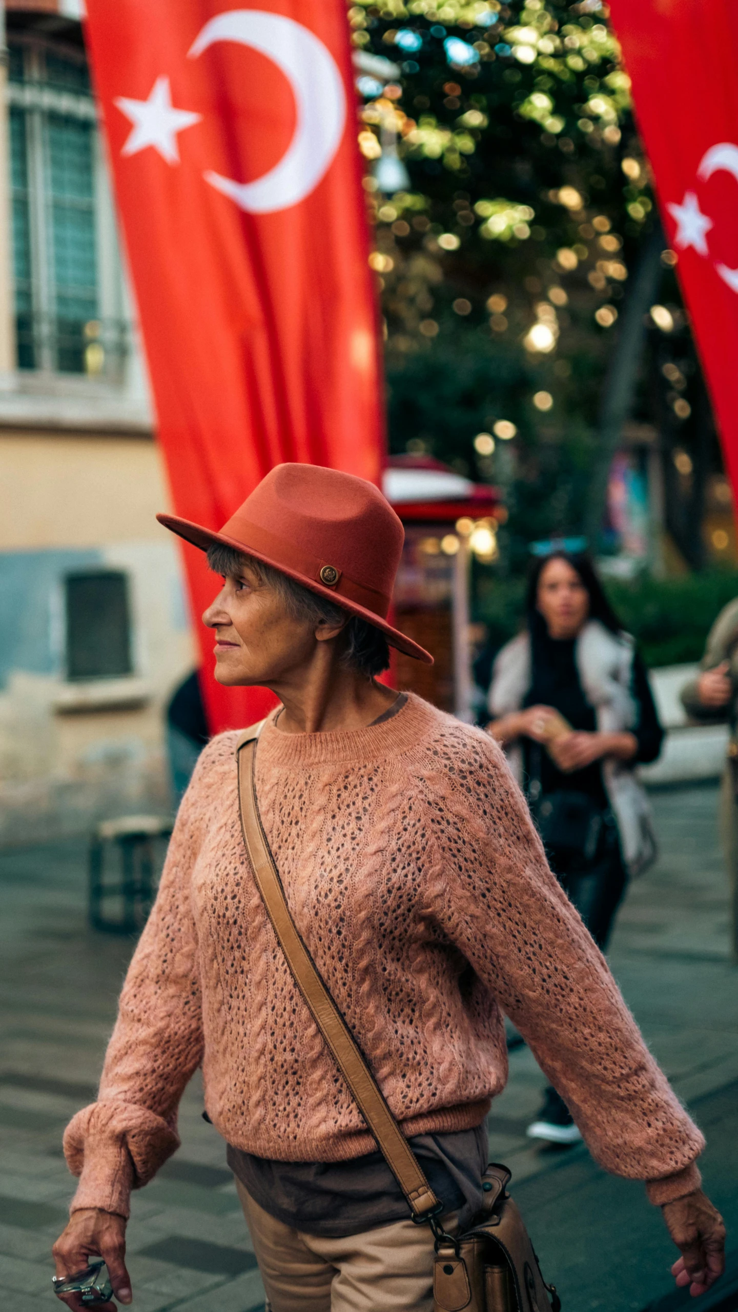 a person walking along a street with flags