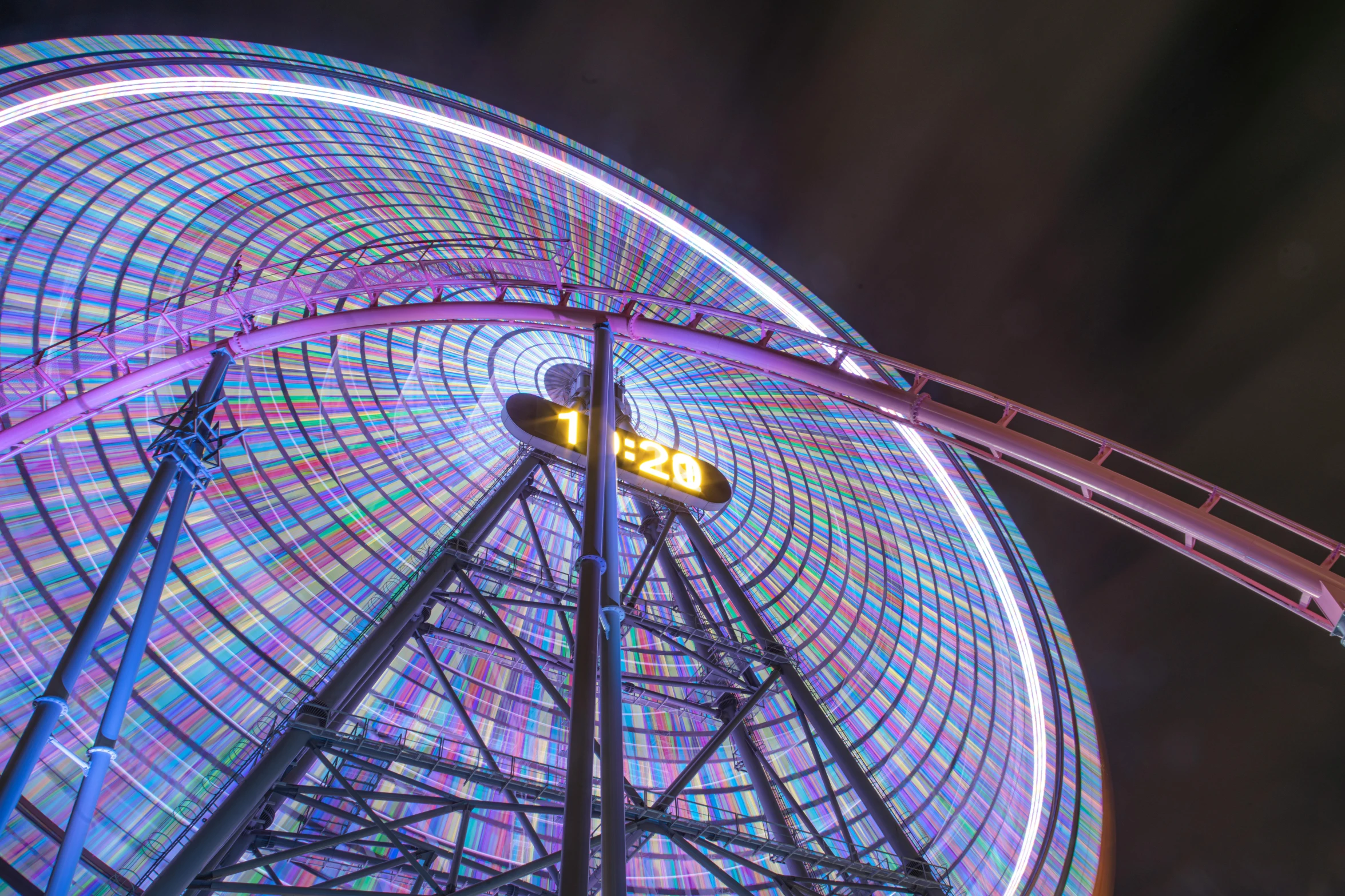 a brightly lit ferris wheel and street signs