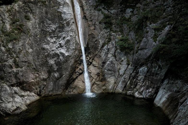 a waterfall that is next to a large cliff