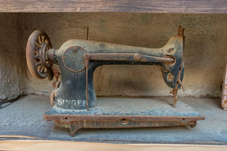 a old fashioned sewing machine sitting in a metal box