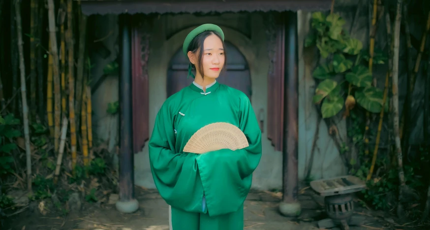 a woman dressed in a green dress posing