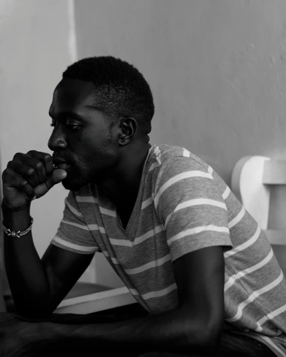 black and white pograph of a man sitting on a toilet