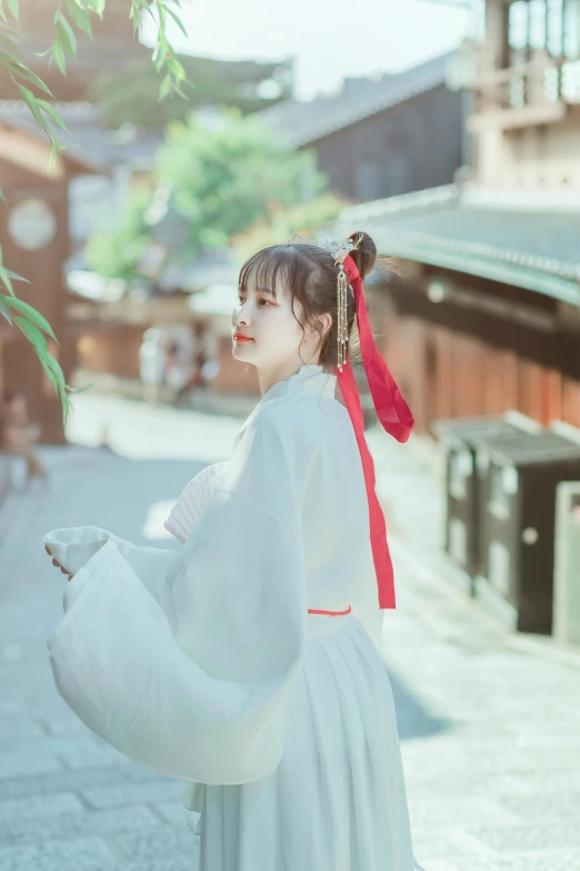 an asian woman wearing white is holding an umbrella