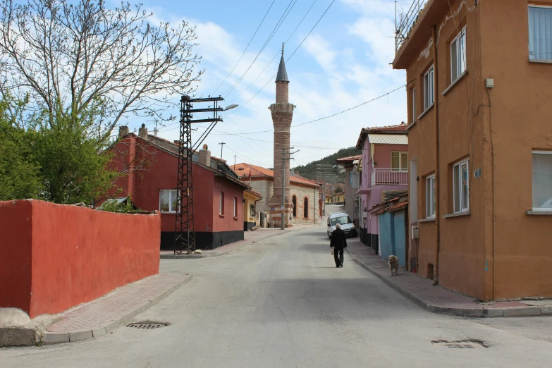 a narrow street leading to a tall tower