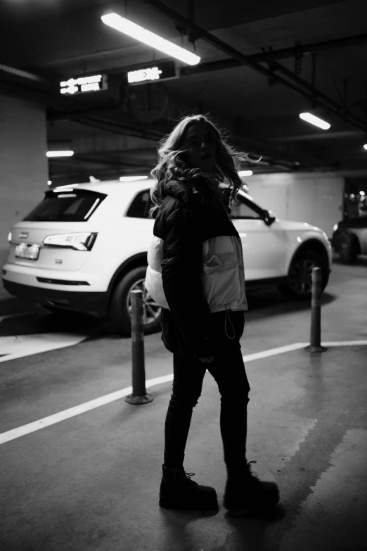 a person in an empty parking garage carrying a backpack