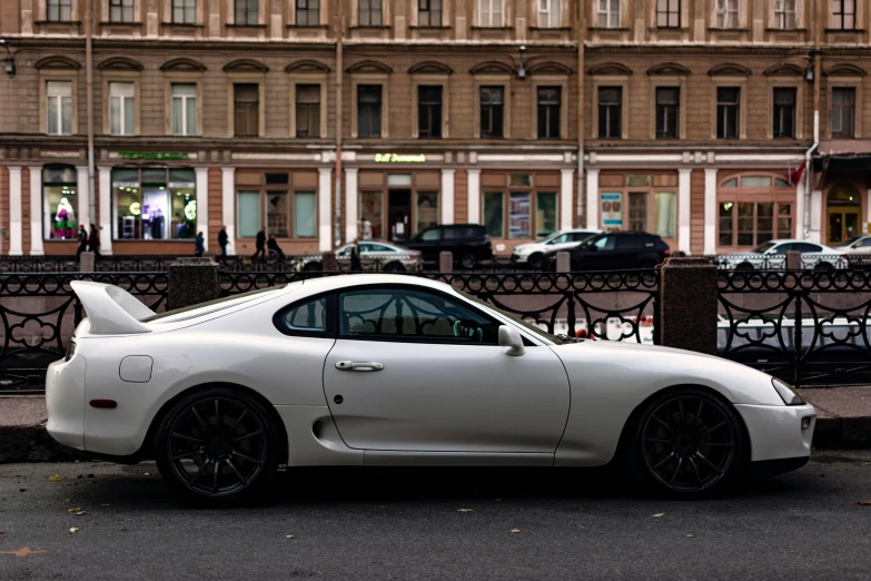 a white car parked next to the street in front of buildings