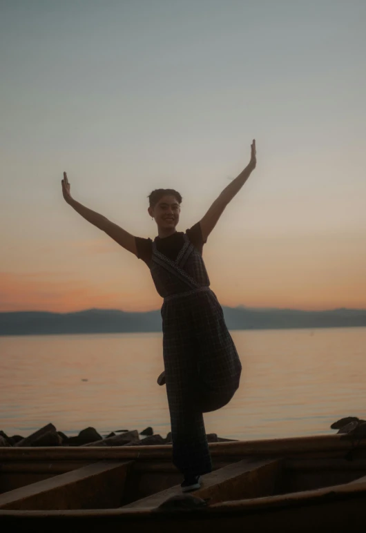 a woman in black dress on the dock near water