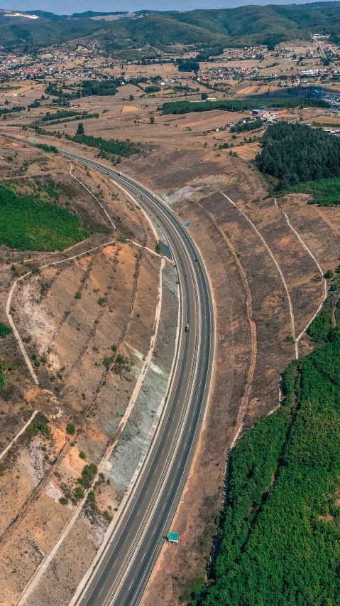 an aerial view of a winding road with cars travelling