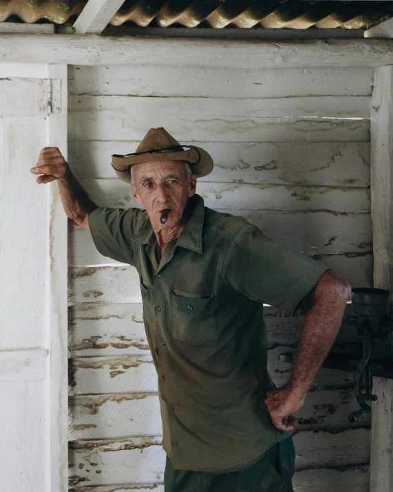 a man posing for the camera in front of an old house