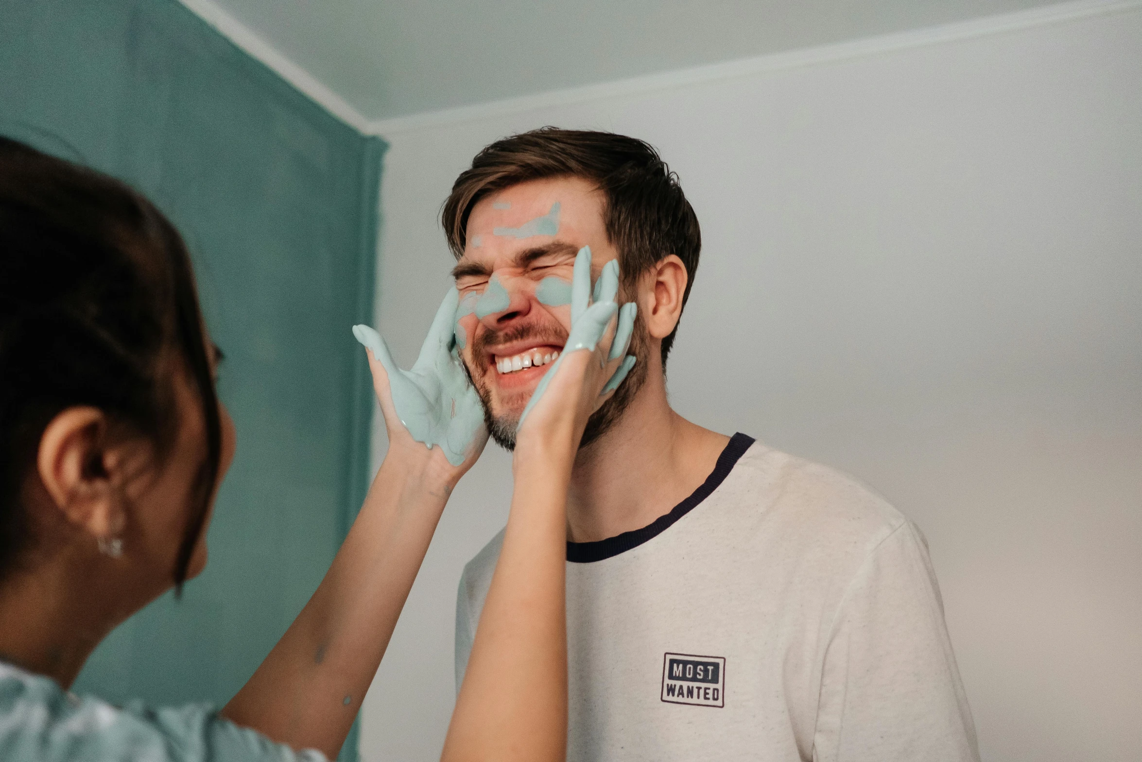 a man with powder on his face and an attractive woman touching his face