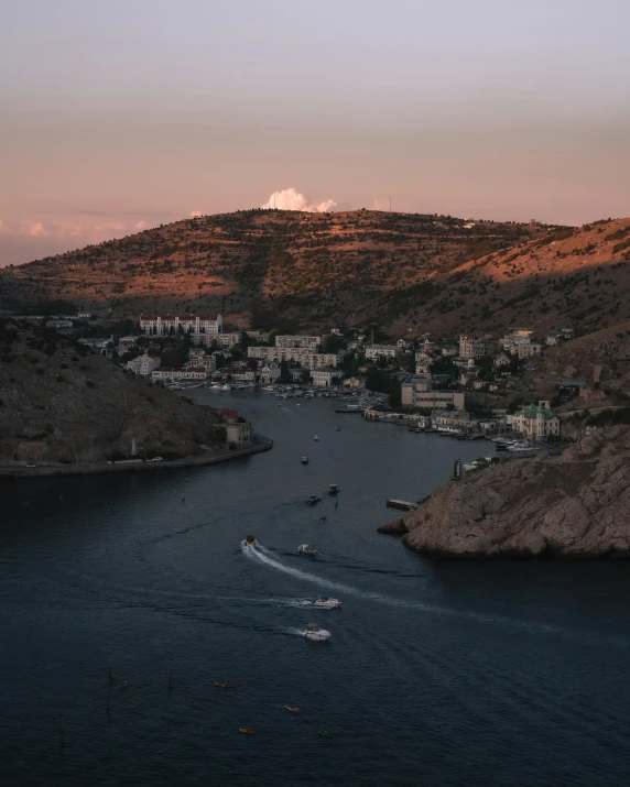 a small boat glides down the ocean in front of the city