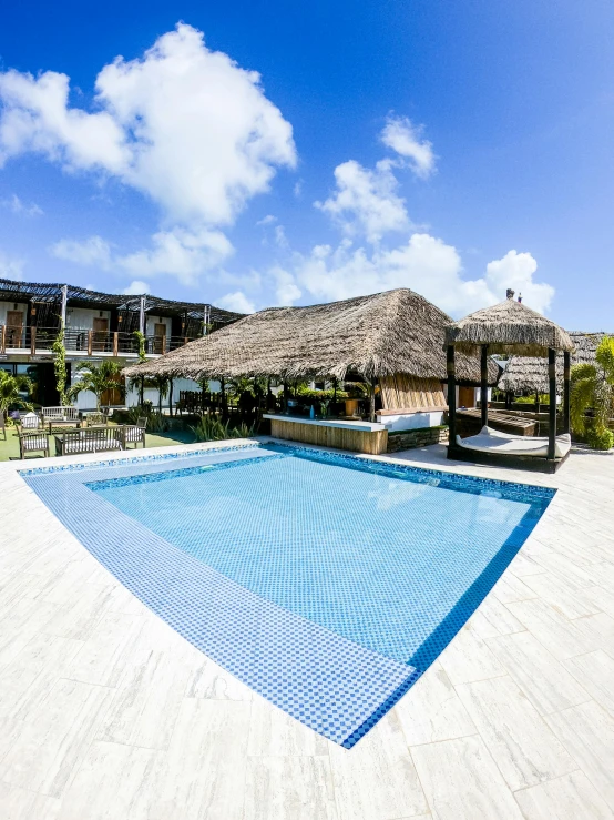 an empty pool is near a tropical resort