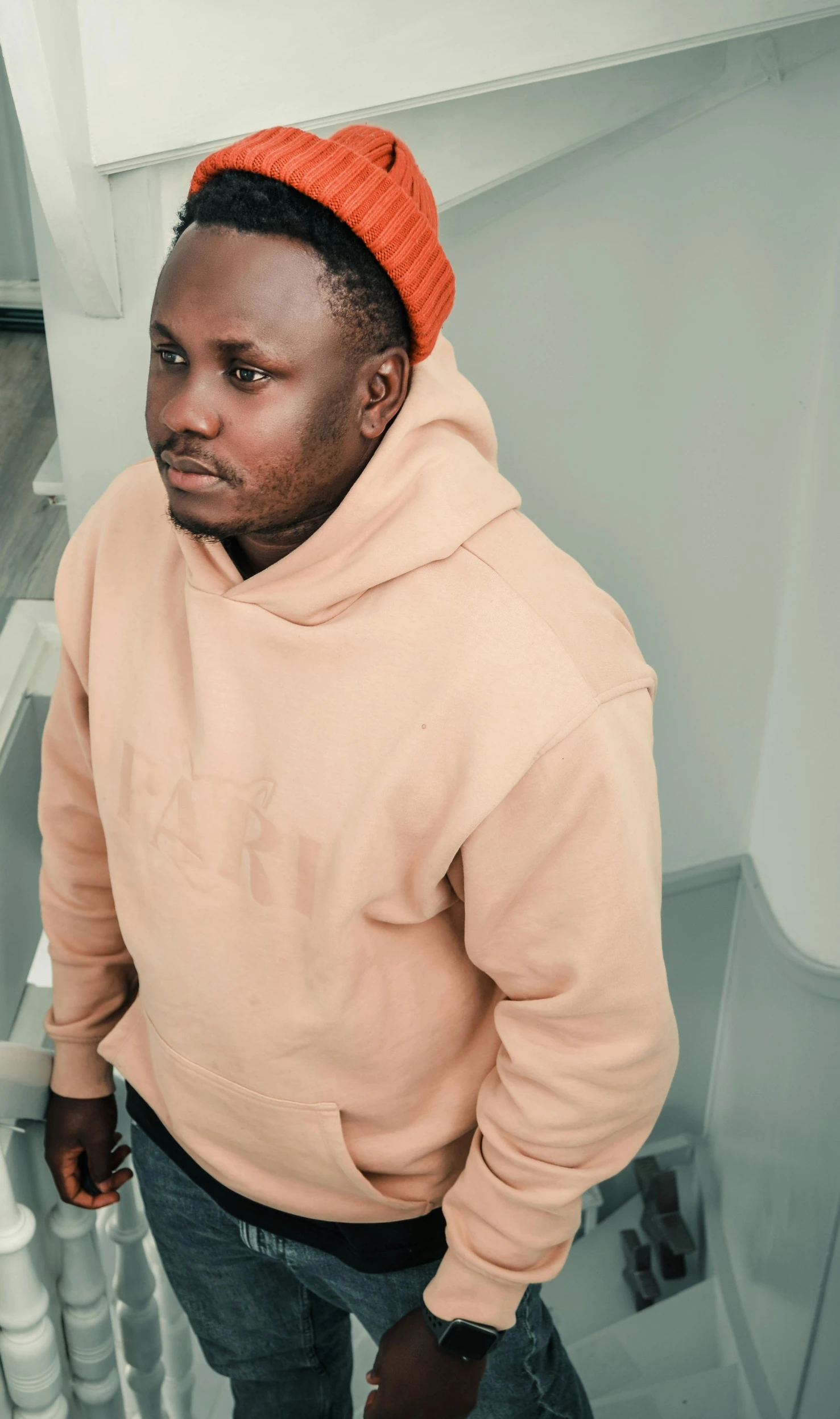 a black man wearing a hoodie in a stairwell