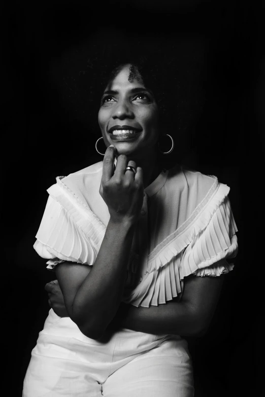 a woman posing in white pants and a white shirt