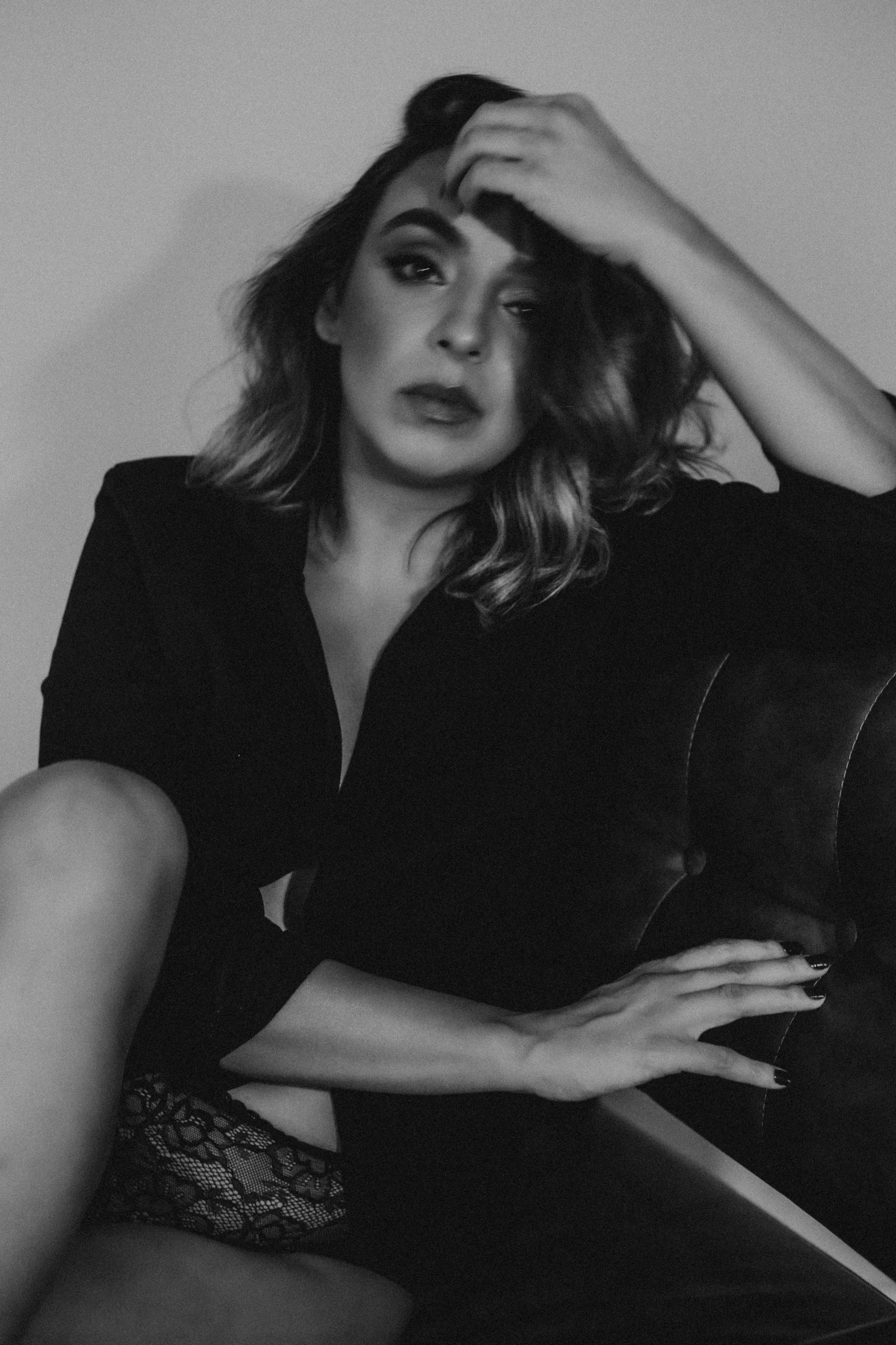 black and white image of woman sitting on couch wearing short sleeved top